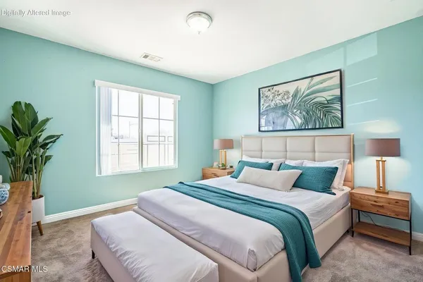 a bedroom with a large bed and a potted plant