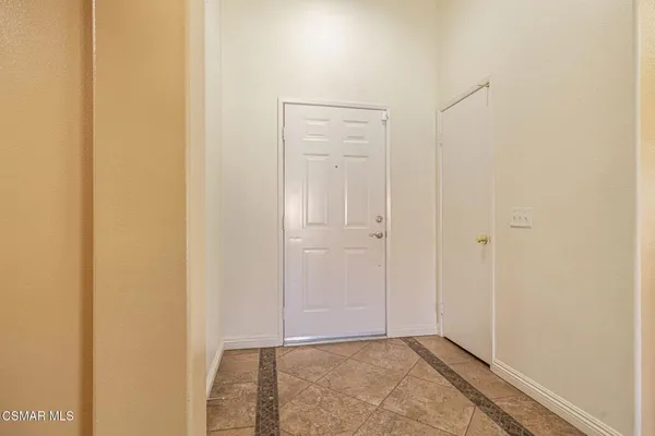 a living room with stainless steel appliances granite countertop a refrigerator microwave and wooden floor