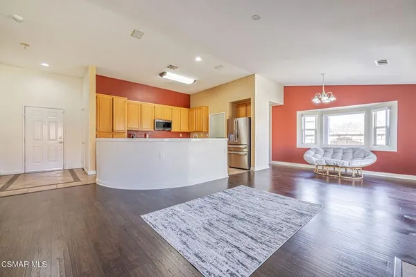 an empty room with wooden floor fireplace and windows