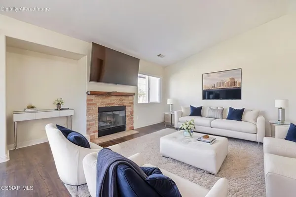 a kitchen with stainless steel appliances kitchen island granite countertop a refrigerator a stove top oven and a sink with couches