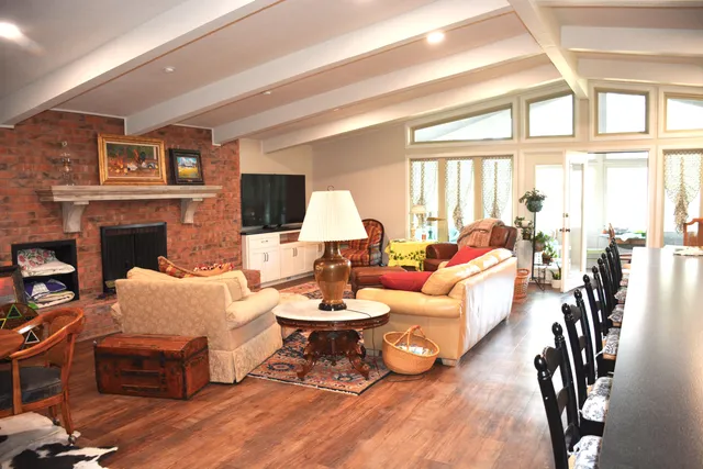 a living room with furniture fireplace and a large window