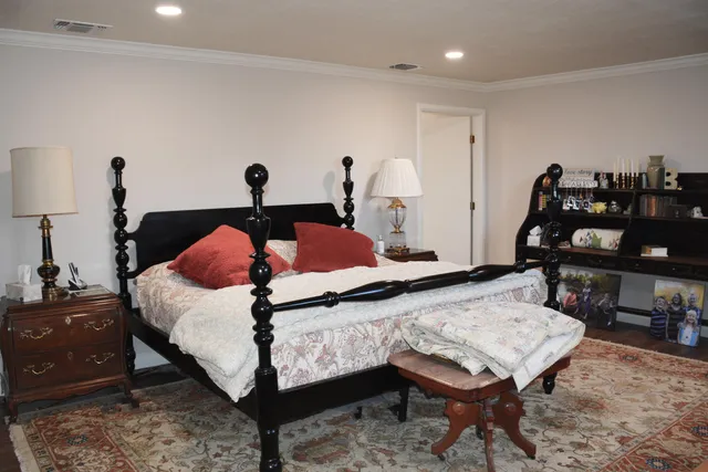 a bedroom with a bed tv and chair