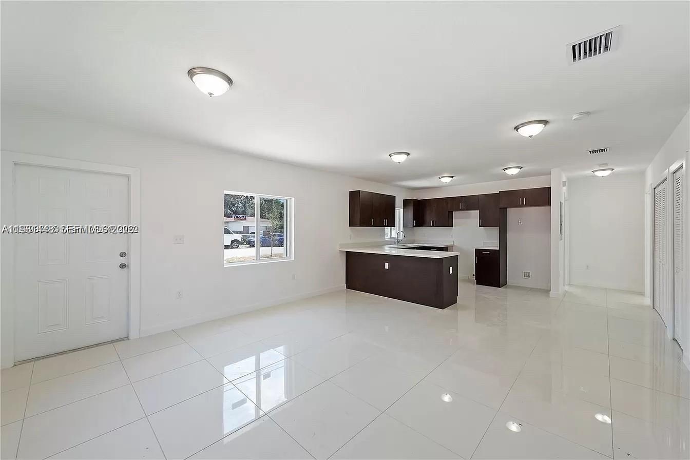 2285 Northwest 91st Street Miami, FL 33147 - Photo 3 of 9 a large white kitchen with a sink a microwave and a refrigerator