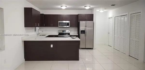 a kitchen with stainless steel appliances a refrigerator stove microwave and sink