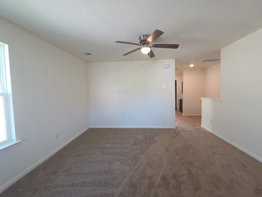 2002 West 2nd Street, Unit 1202 Taylor, TX 76574 - Photo 5 of 15 Living room area with natural light, ceiling fan, and carpet