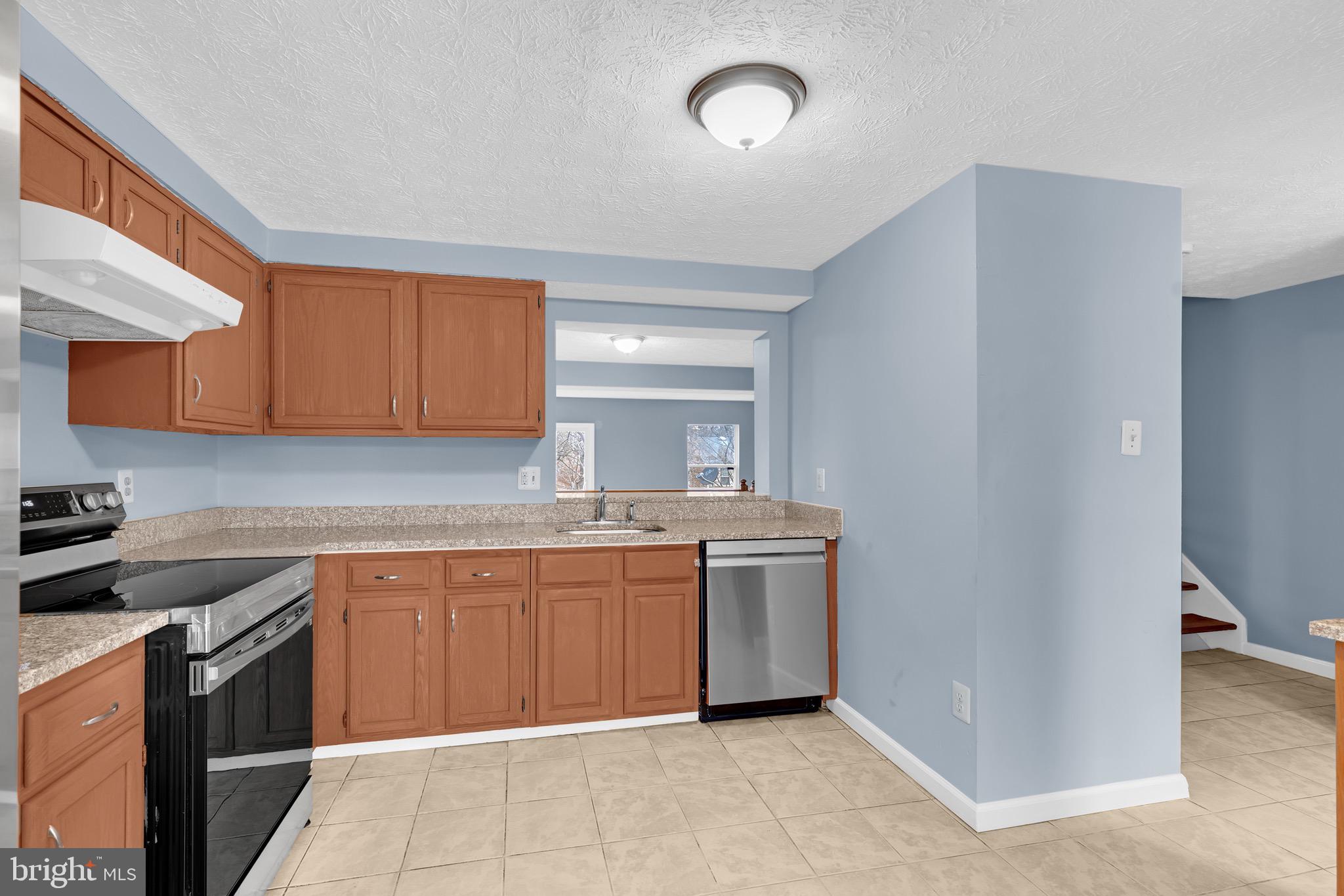 7600 Mandan Road Greenbelt, MD 20770 - Photo 11 of 42 a kitchen with stainless steel appliances granite countertop a sink and a stove top oven