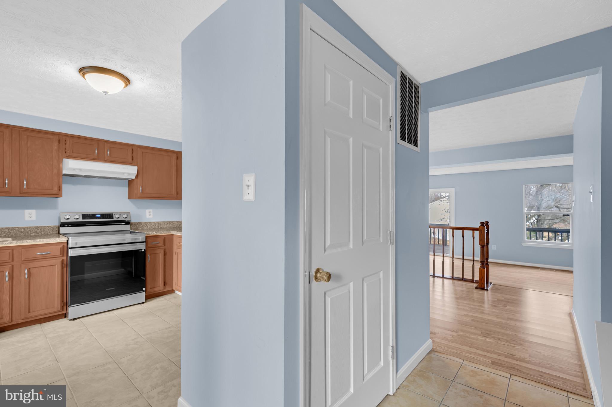 7600 Mandan Road Greenbelt, MD 20770 - Photo 5 of 42 a view of a kitchen with a stove wooden cabinets and a refrigerator