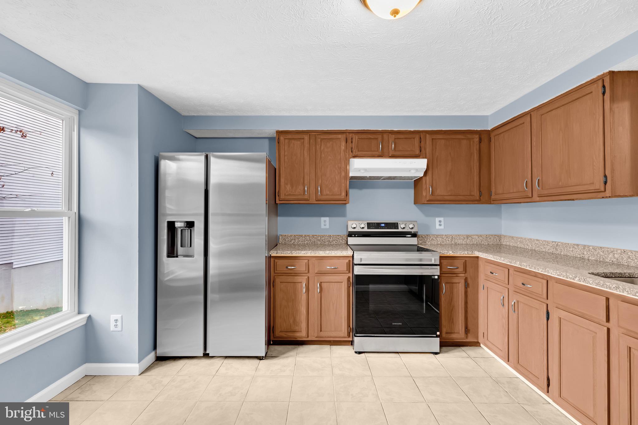 7600 Mandan Road Greenbelt, MD 20770 - Photo 8 of 42 a kitchen with stainless steel appliances granite countertop a stove and a refrigerator