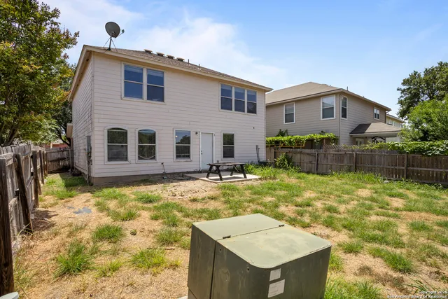 a backyard of a house with barbeque oven and table
