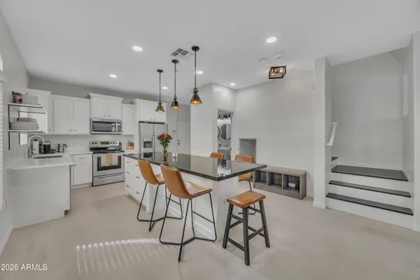 a kitchen with stainless steel appliances kitchen island granite countertop a sink and cabinets