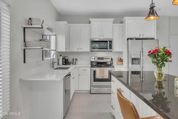 a kitchen with stainless steel appliances granite countertop a sink a stove and a refrigerator
