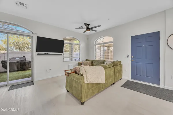 a living room with furniture a flat screen tv and a floor to ceiling window