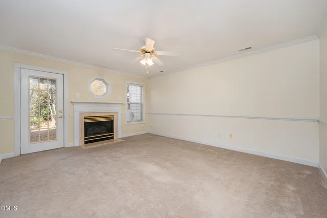 a view of empty room with fan and fireplace
