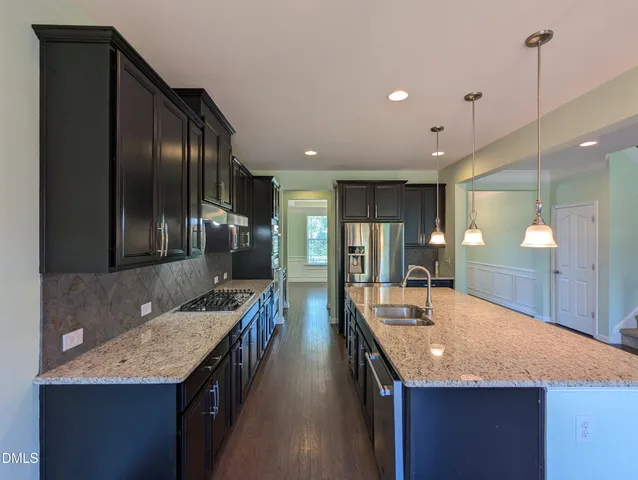 a kitchen with kitchen island a sink and refrigerator