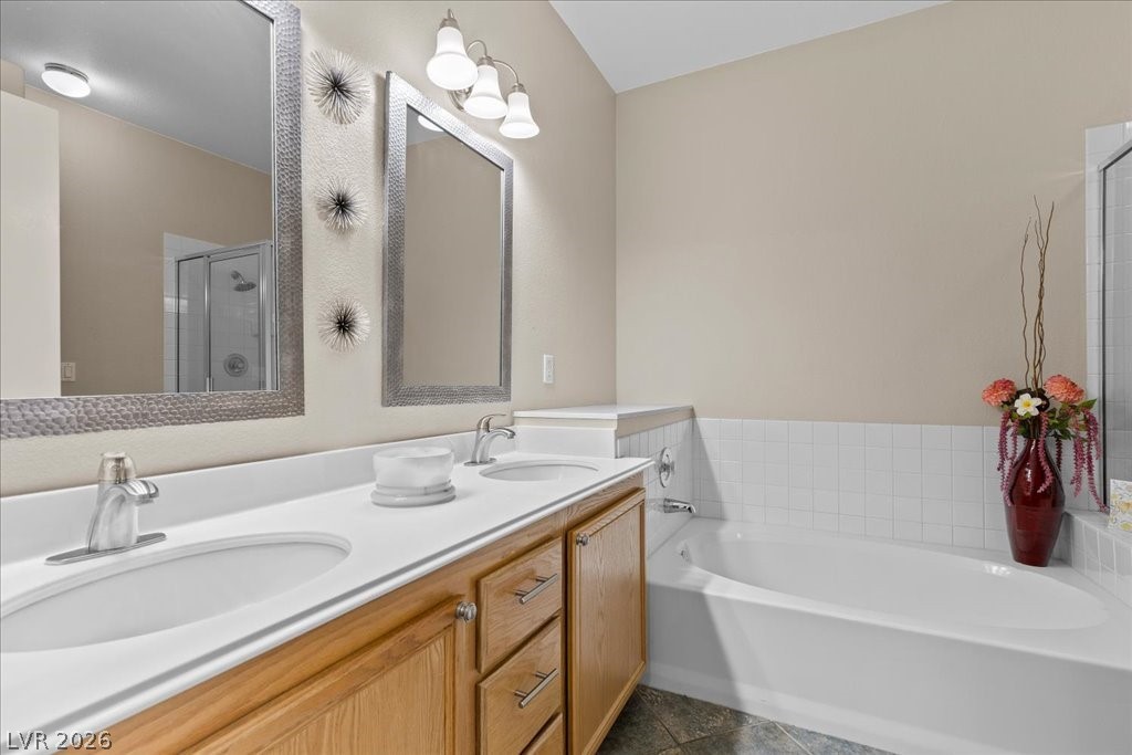 2201 Ramsgate Drive, Unit 818 Henderson, NV 89074 - Photo 13 of 32 Bathroom featuring double vanity, a bath, and a stall shower