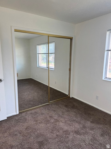 1797 West 950 North, Unit 2 St. George, UT 84770 - Photo 10 of 11 Room featuring wall-to-wall carpeting and a large mirrored closet with gold-tone framing