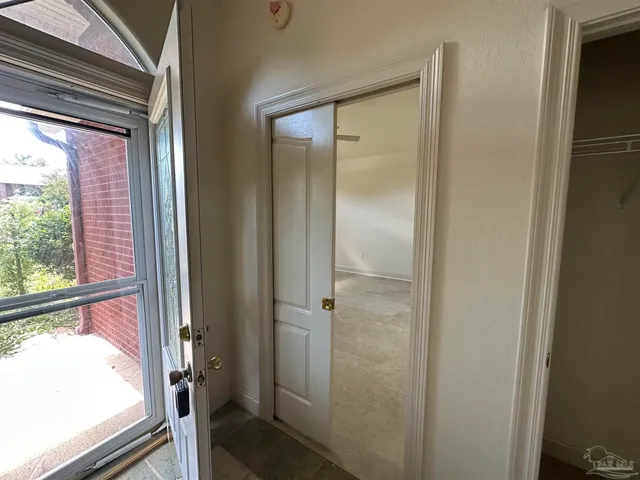 an empty room with windows and fan