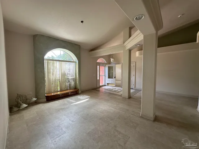 an empty room with a window and a ceiling fan