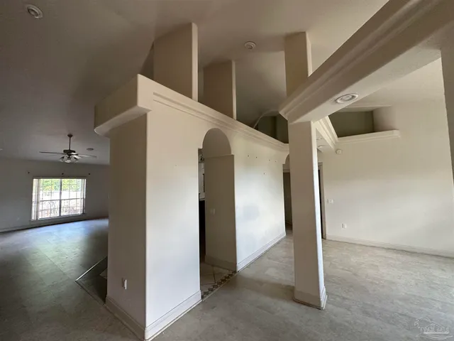 a view of a livingroom with wall paintings and a fan