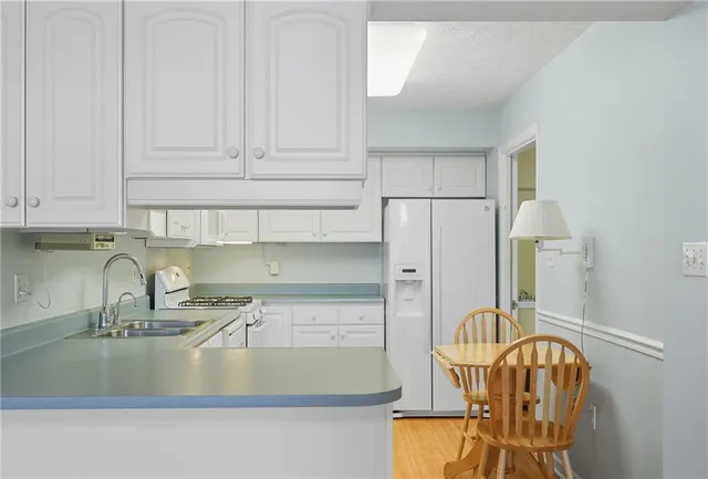 a kitchen with cabinets stainless steel appliances and a sink