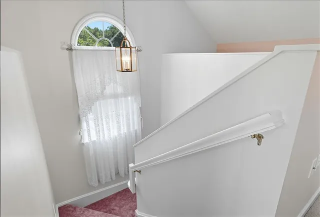 an empty room with windows and chandelier fan