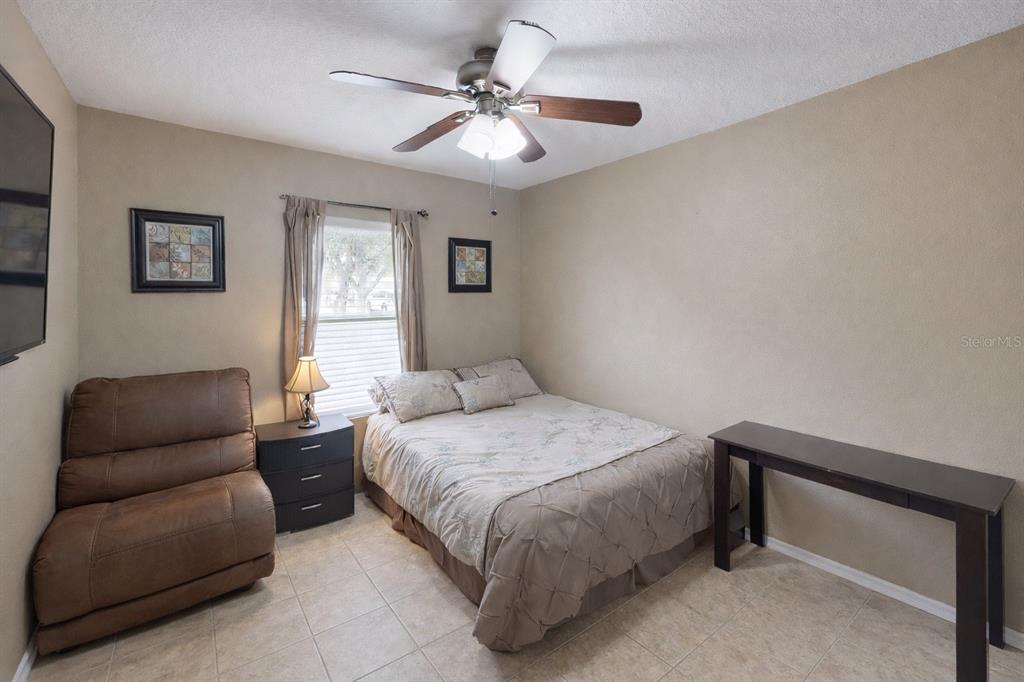 4354 Fieldview Circle Wesley Chapel, FL 33545 - Photo 13 of 15 a bedroom with a bed couch and window