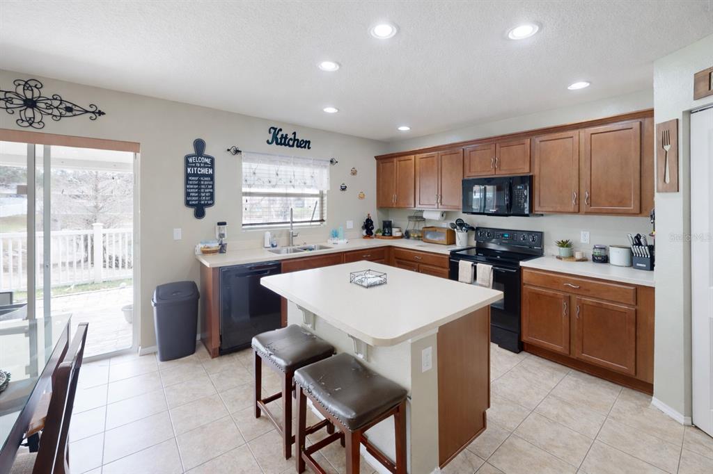 4354 Fieldview Circle Wesley Chapel, FL 33545 - Photo 5 of 15 a kitchen with a refrigerator a stove top oven a sink dishwasher and white cabinets with wooden floor