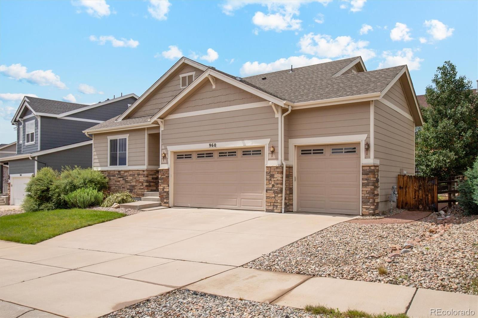 960 Fire Rock Place Colorado Springs, CO 80921 - Photo 3 of 32 a front view of a house with a yard and garage