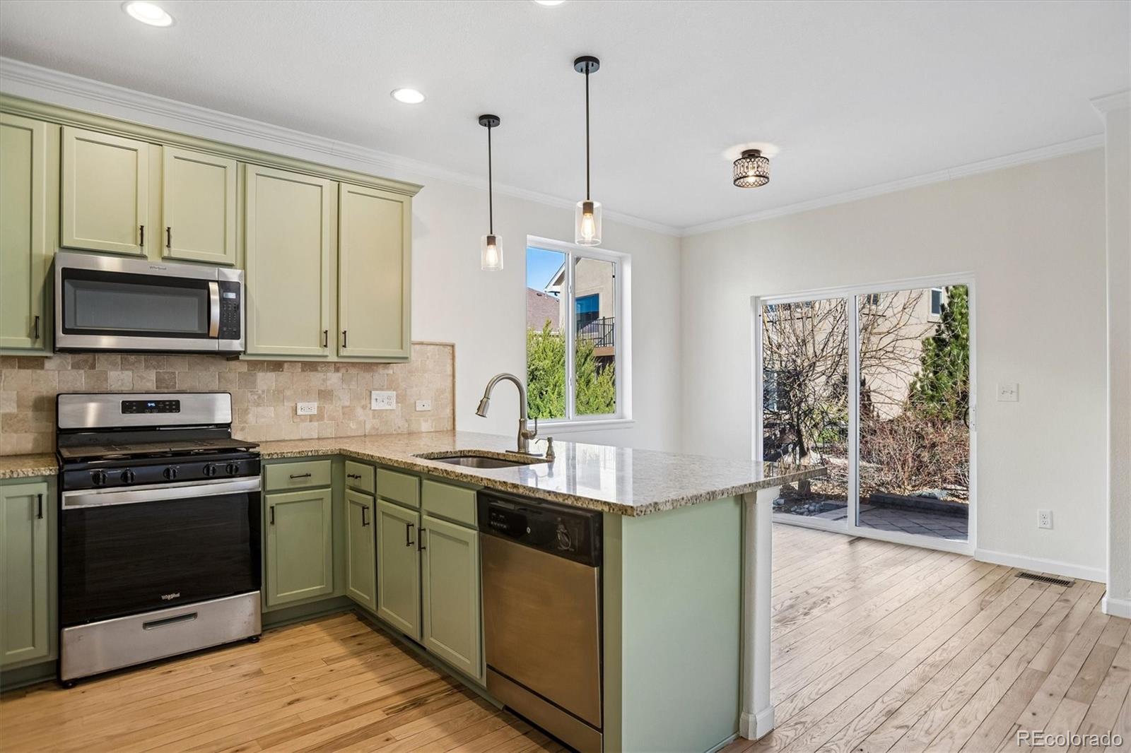960 Fire Rock Place Colorado Springs, CO 80921 - Photo 7 of 32 a kitchen with stainless steel appliances granite countertop a stove a sink and a microwave