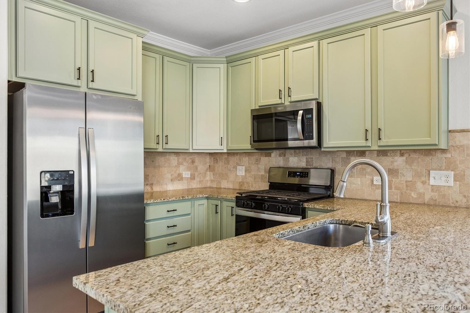 960 Fire Rock Place Colorado Springs, CO 80921 - Photo 8 of 32 a kitchen with stainless steel appliances granite countertop a refrigerator a stove a sink and a white cabinets