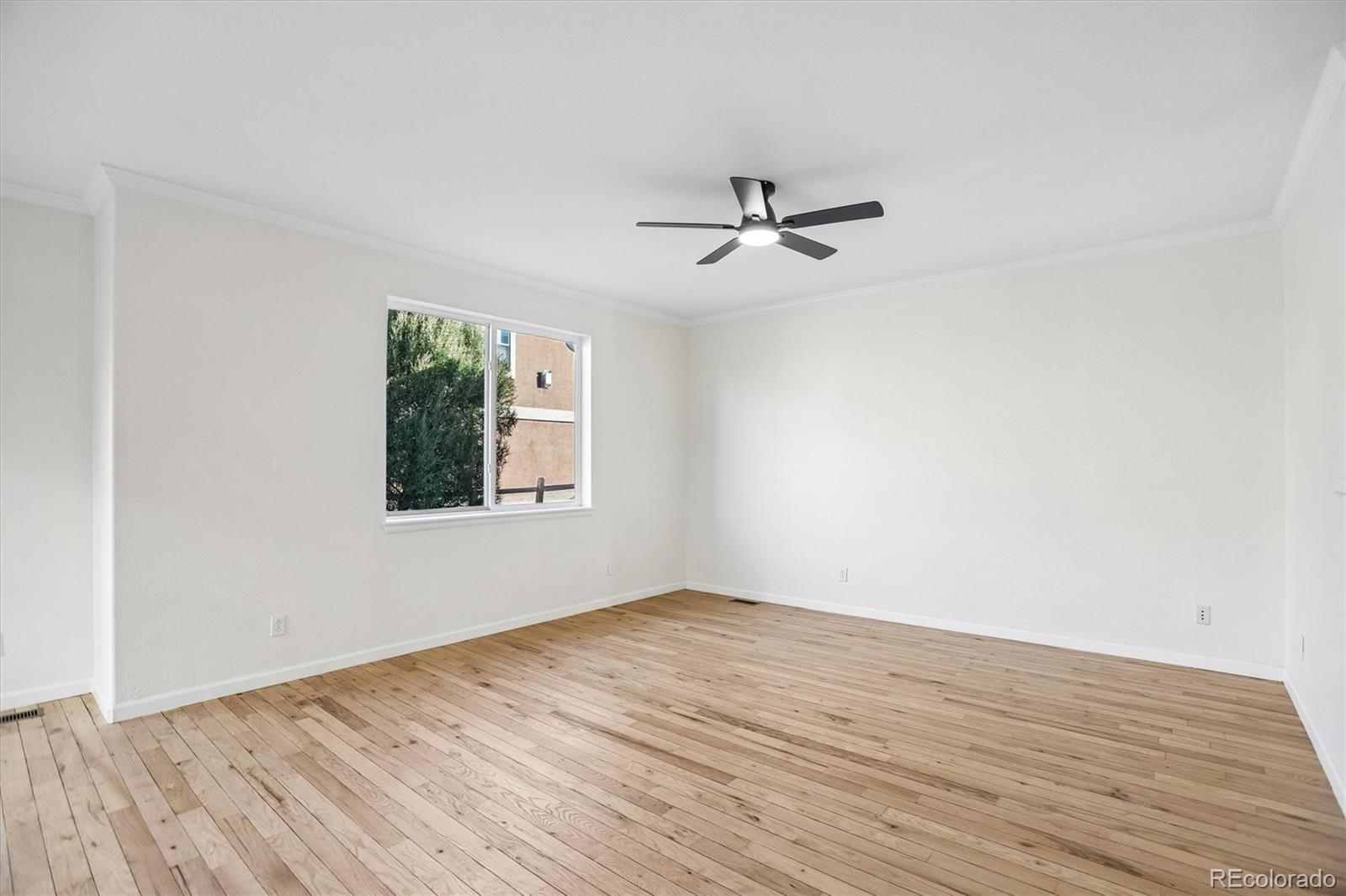 960 Fire Rock Place Colorado Springs, CO 80921 - Photo 10 of 32 a view of empty room with wooden floor and fan