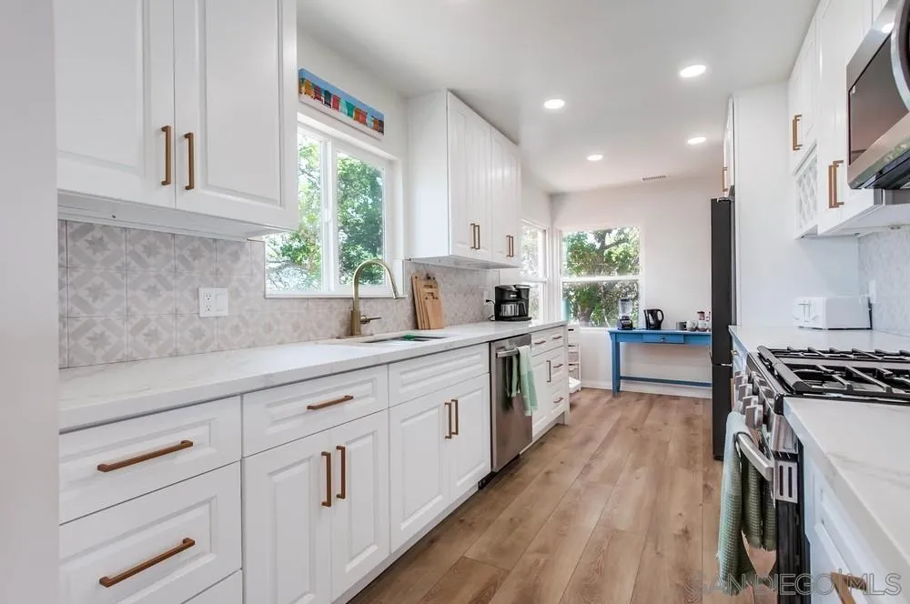 4724 Troy Lane La Mesa, CA 91942 - Photo 12 of 49 a kitchen with white cabinets and white appliances