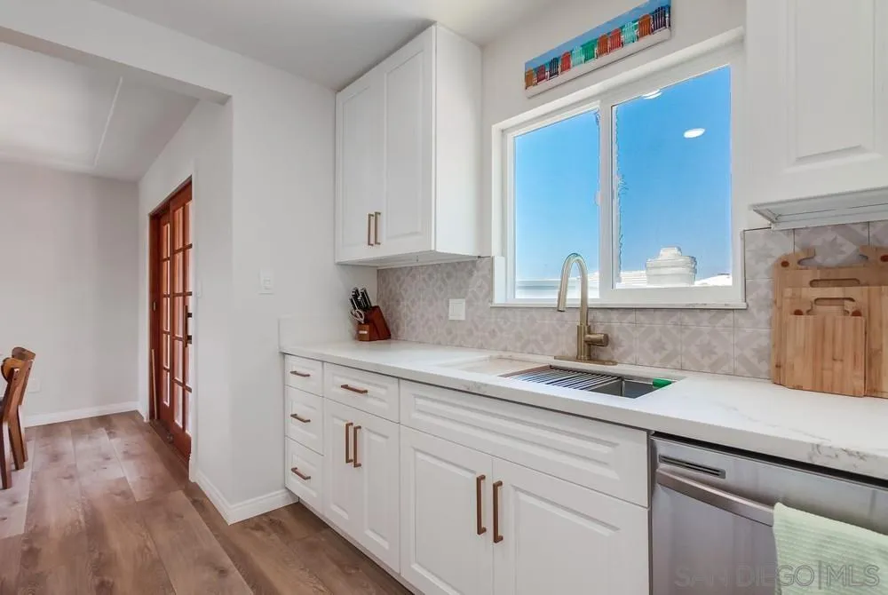 4724 Troy Lane La Mesa, CA 91942 - Photo 17 of 49 a kitchen with granite countertop white cabinets and white appliances