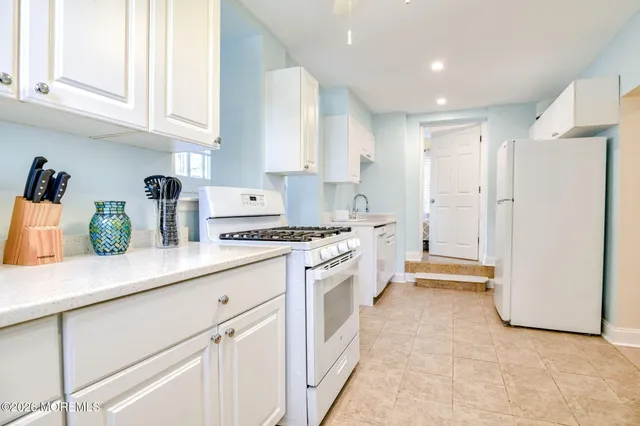 a kitchen with white cabinets and white appliances