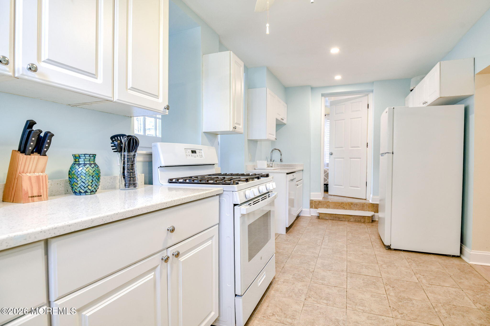 18 Abbott Avenue, Unit GARDEN Ocean Grove, NJ 07756 - Photo 13 of 16 a kitchen with white cabinets and white appliances