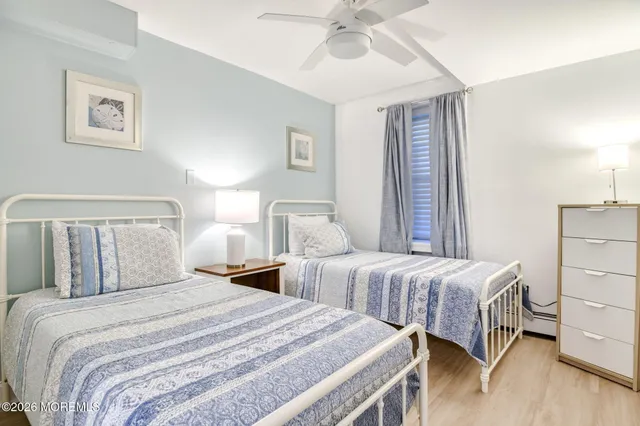 a bedroom with two beds and painting on the wall