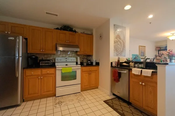 a kitchen with stainless steel appliances granite countertop a refrigerator and a stove