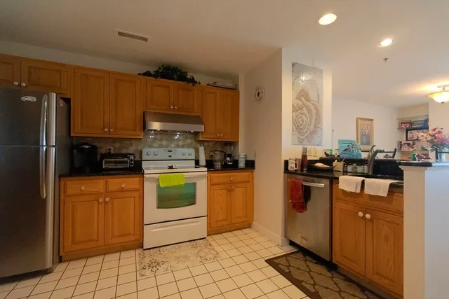 a kitchen with stainless steel appliances granite countertop a refrigerator and a stove