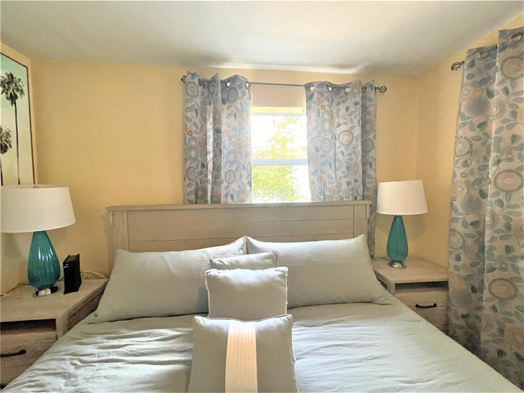 5106 104th Street North St. Petersburg, FL 33708 - Photo 17 of 35 a bedroom with a bed and a lamp