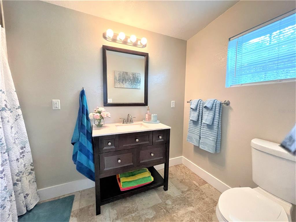 5106 104th Street North St. Petersburg, FL 33708 - Photo 18 of 35 a bathroom with a toilet a sink and a mirror