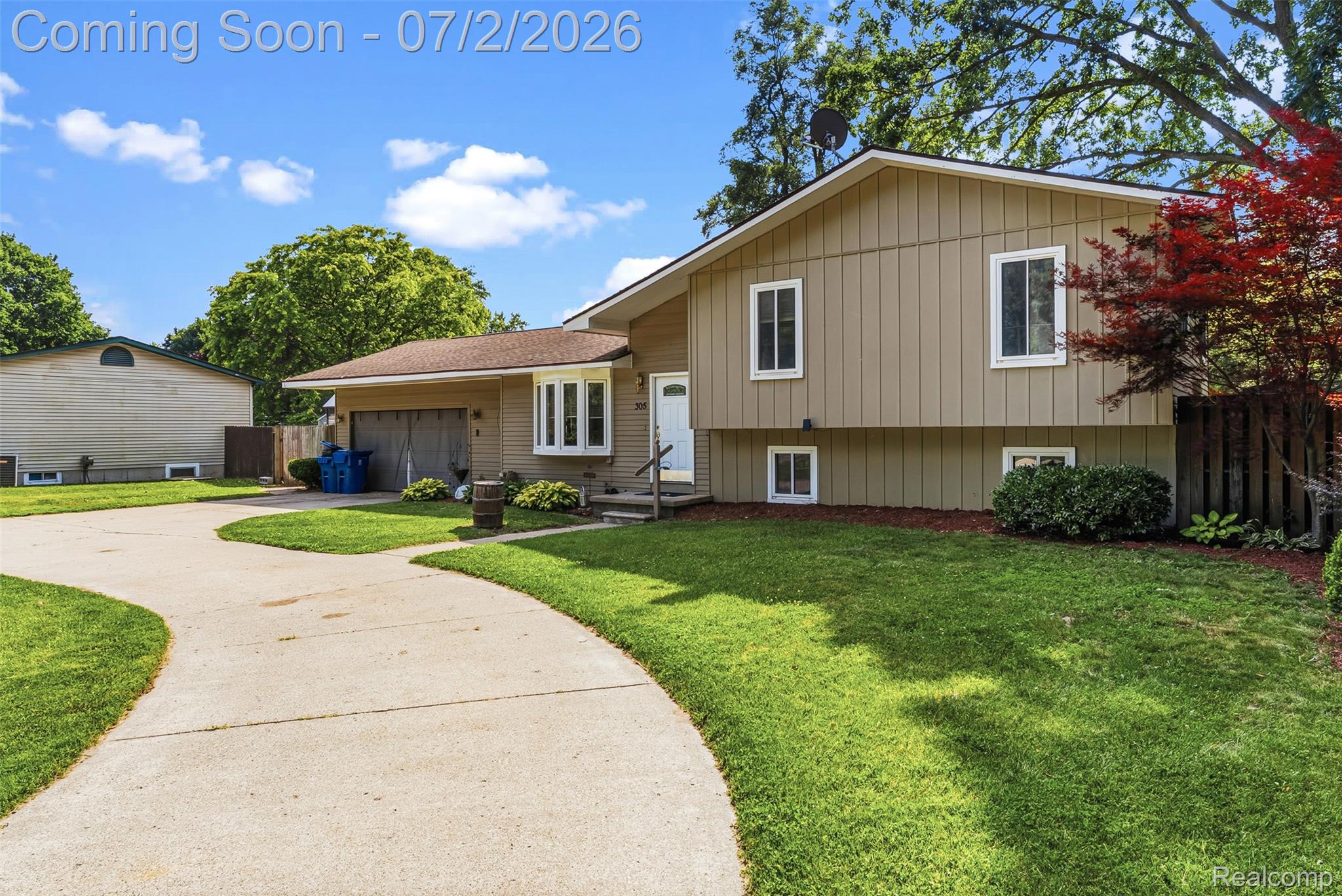 305 East Road Holly, MI 48442 - Photo 3 of 41 Spacious split-level residence featuring a multi-pane bay window, attached garage, and a curved concrete driveway