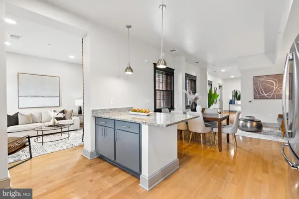 a kitchen with stainless steel appliances granite countertop a refrigerator a stove a sink and a refrigerator with wooden floor