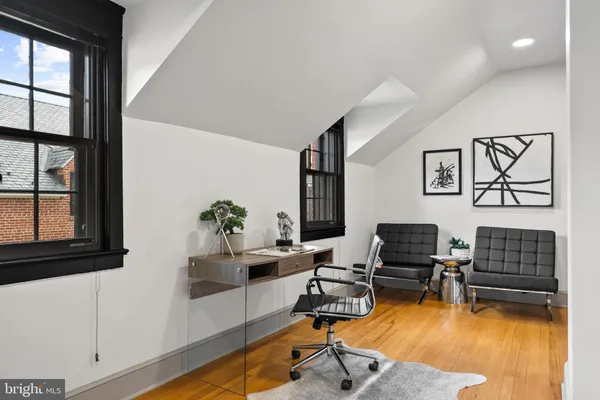 a view of staircase with lots of frames on wall and windows