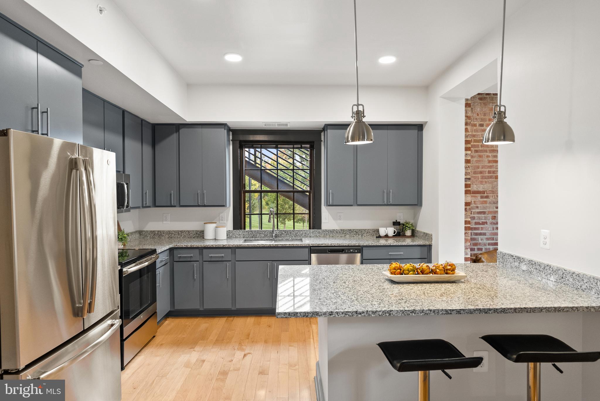 9071 Power House Road, Unit 102 Lorton, VA 22079 - Photo 9 of 50 a kitchen with stainless steel appliances granite countertop a sink refrigerator and cabinets