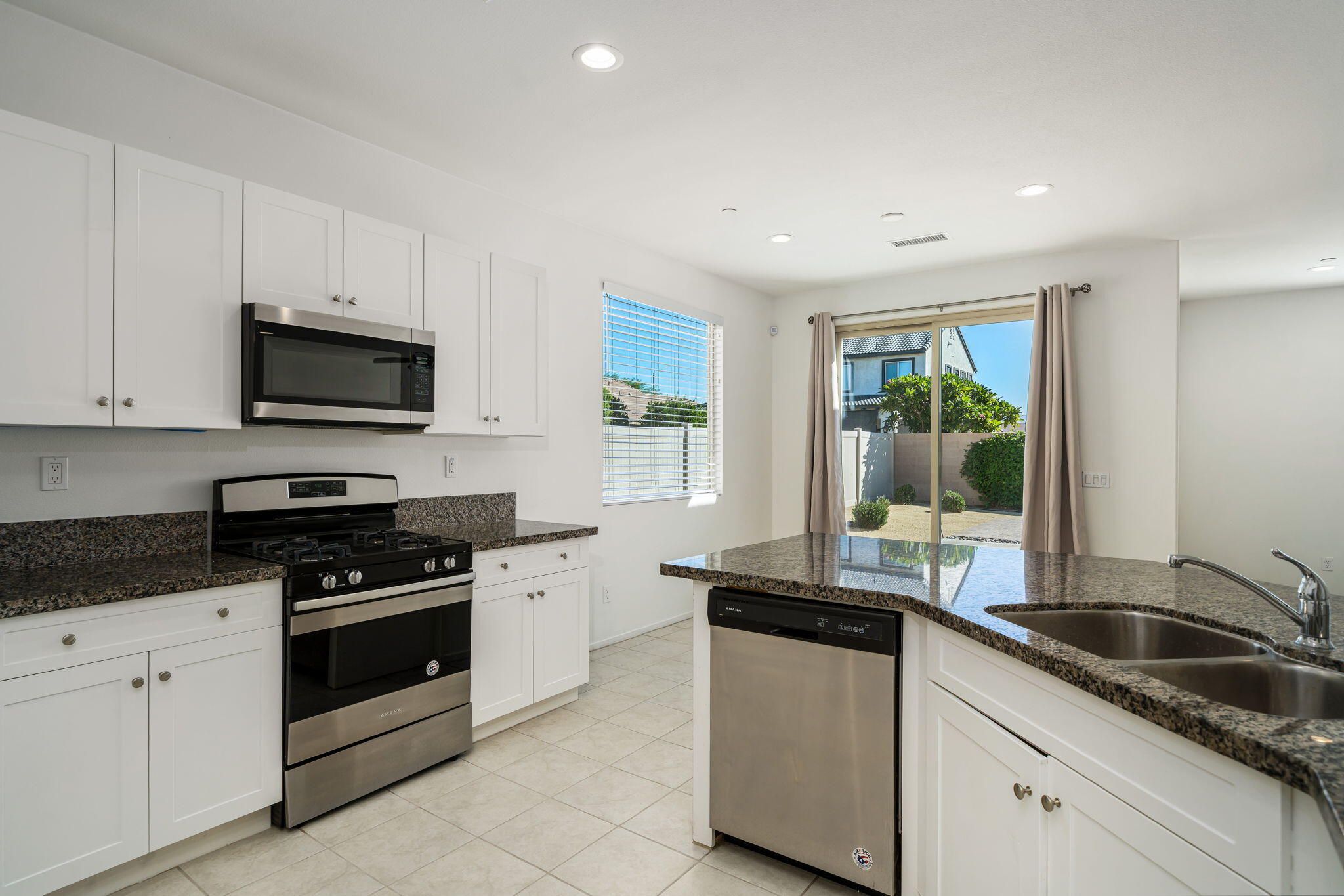 50252 Paseo Barcelona Coachella, CA 92236 - Photo 4 of 23 a kitchen with granite countertop a sink a stove top oven and cabinetry