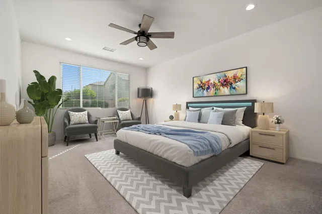 a spacious bedroom with a bed a couch and a potted plant