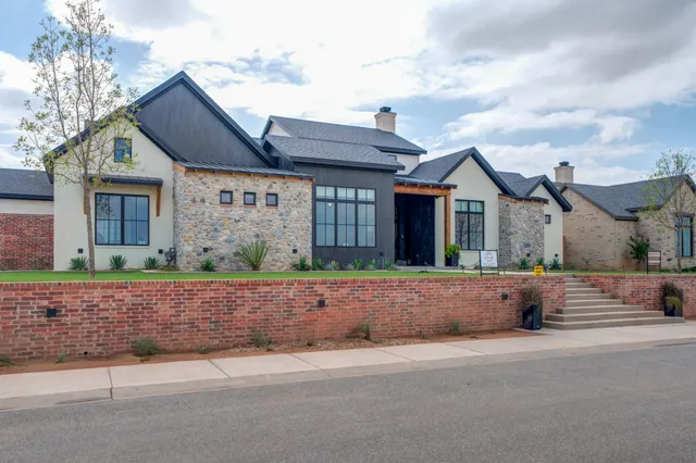 an aerial view of residential houses with outdoor space and ocean view