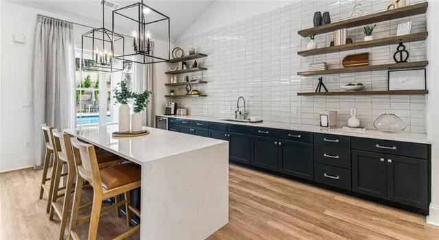 a kitchen with stainless steel appliances granite countertop a sink a stove and a wooden cabinets