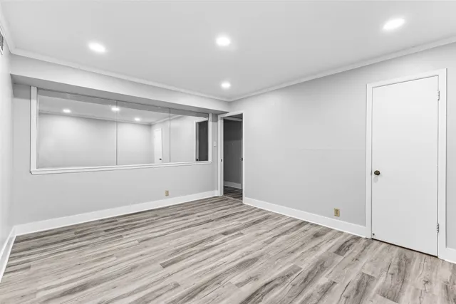 a view of an empty room with wooden floor