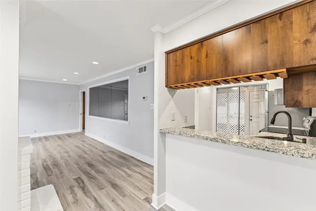 a view of a kitchen with a sink and wooden floor